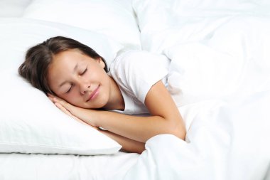 Beyaz yatakta uyuyan güzel kız