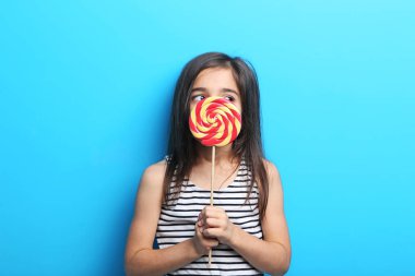 Güzel küçük bir kız ile mavi arka plan üzerinde lolipop