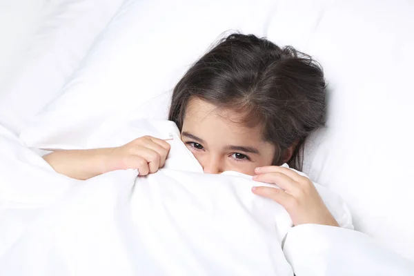 Belle petite fille dormant dans un lit blanc — Photo