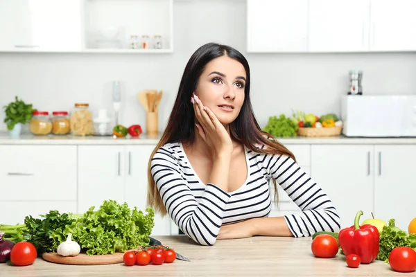 Красива молода жінка з овочами на кухні — стокове фото