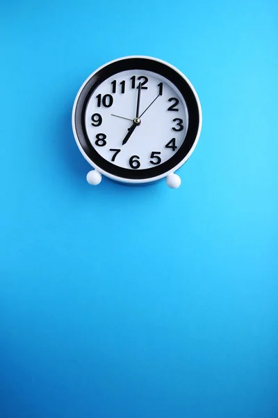 Schwarze Uhr auf blauem Hintergrund — Stockfoto