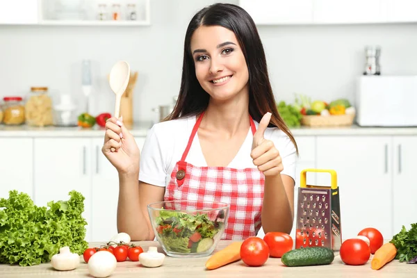 Bella giovane donna che cucina insalata in cucina — Foto Stock