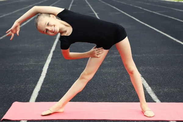 Genç kız jimnastikçi pembe fitness mat