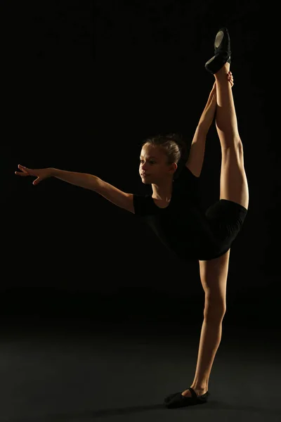 Νεαρό κορίτσι γυμναστής σε μαύρο φόντο — Φωτογραφία Αρχείου