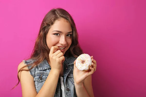 Porträt einer jungen Frau mit süßem Donut auf rosa Hintergrund — Stockfoto