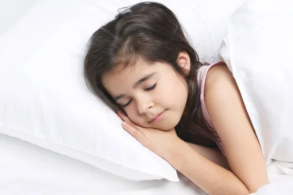 Belle petite fille dormant dans un lit blanc — Photo