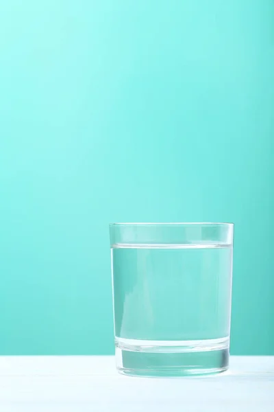 Glass with water on mint background — Stock Photo, Image