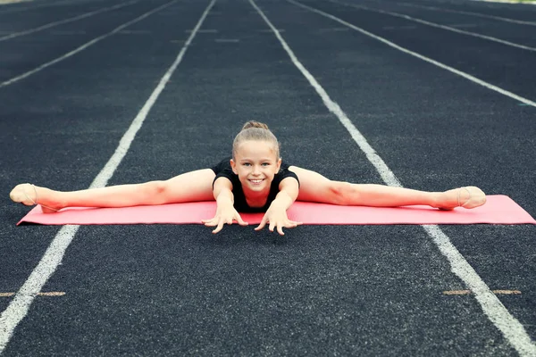 Chica joven gimnasta en rosa alfombra de fitness —  Fotos de Stock