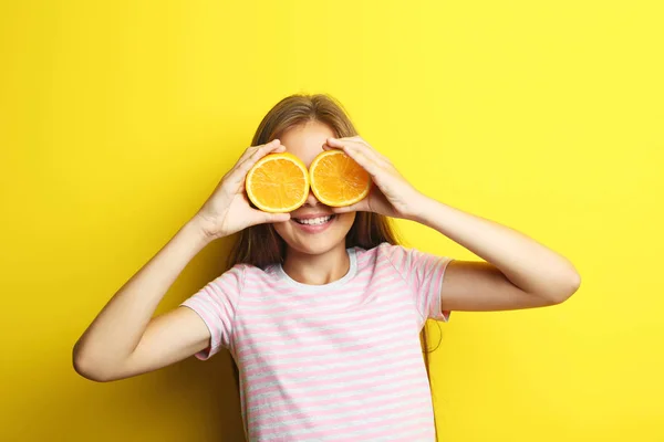 Potret gadis cantik dengan buah jeruk pada backgroun kuning — Stok Foto