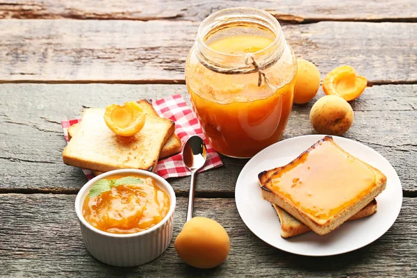 Abrikozenjam in kom en glazen pot — Stockfoto