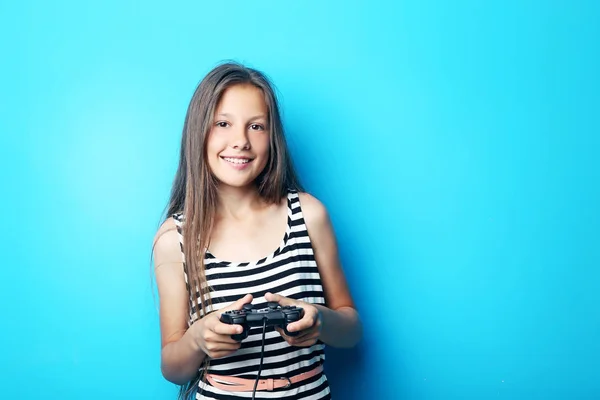 Porträtt av vackra flicka med joystick på blå bakgrund — Stockfoto