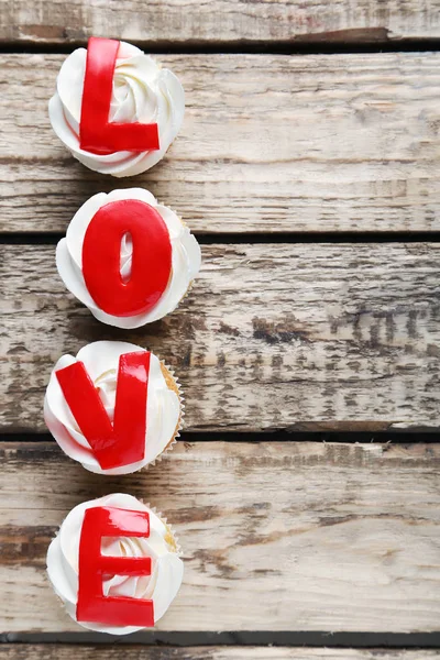 Leckere Cupcakes auf einem braunen Holztisch — Stockfoto