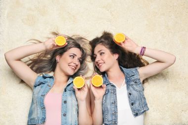 İki genç kadın turuncu meyve halı döşeme