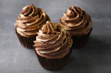 Gri ahşap masa üzerinde çikolata cupcakes
