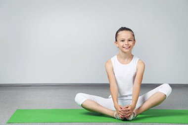 Genç kız yeşil yoga mat egzersizleri yapıyor