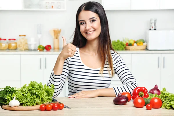 Mulher bonita com legumes na cozinha — Fotografia de Stock