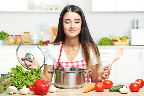 Vacker ung kvinna matlagning sallad i köket — Stockfoto