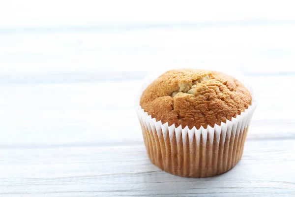 Tasty muffin on a white wooden table — Stock Photo, Image