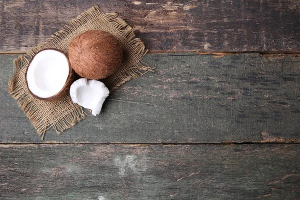 Kokosnoten met zak op houten tafel — Stockfoto