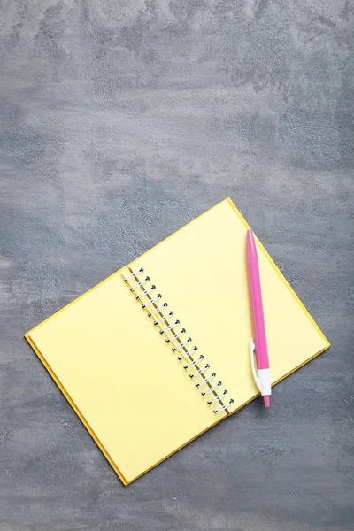 Caderno com caneta na mesa cinzenta — Fotografia de Stock