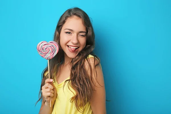 Porträtt av ung kvinna med lollipop på blå bakgrund — Stockfoto