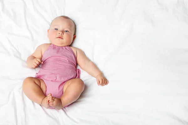 Lilla nyfödda baby på vit säng — Stockfoto