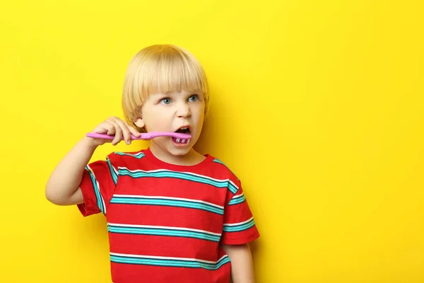 Portret van kleine jongen met tandenborstel op gele achtergrond — Stockfoto