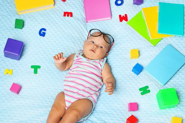 Bayi kecil yang baru lahir dengan buku dan surat di tempat tidur — Stok Foto