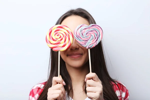 Ung kvinna med lollipop på grå bakgrund — Stockfoto