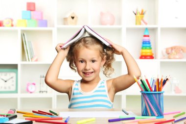 Kitap masada oturan küçük kız