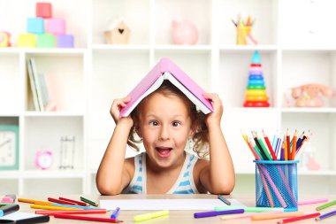 Kitap masada oturan küçük kız