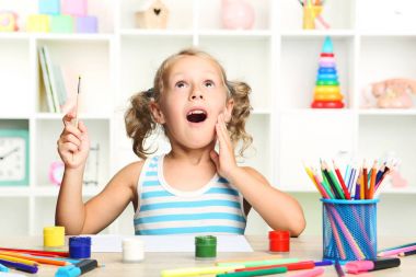 Oturma ve masada çizim küçük kız