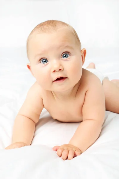 Pequeno bebê recém-nascido na cama branca — Fotografia de Stock