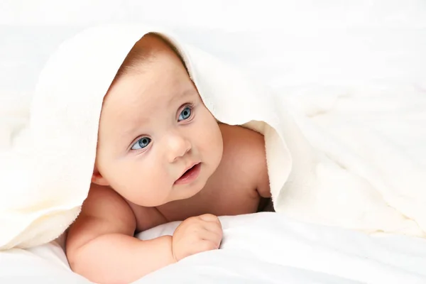 Little newborn baby with towel on white bed — Stock Photo, Image