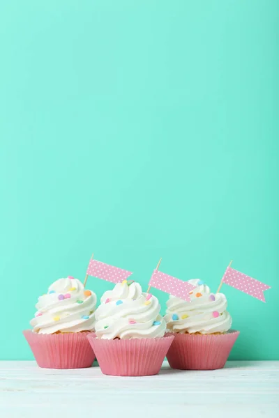 Tasty cupcakes on a green background — Stock Photo, Image