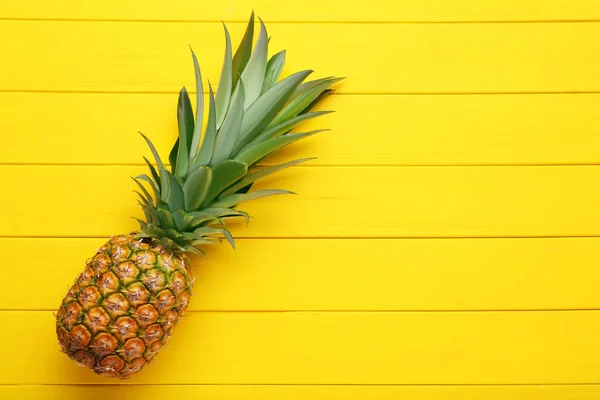 Ripe pineapple on yellow wooden table — Stock Photo, Image