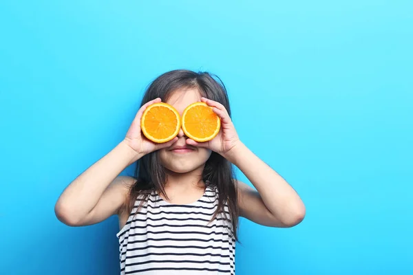 Gadis kecil cantik dengan warna oranye dengan latar belakang biru — Stok Foto