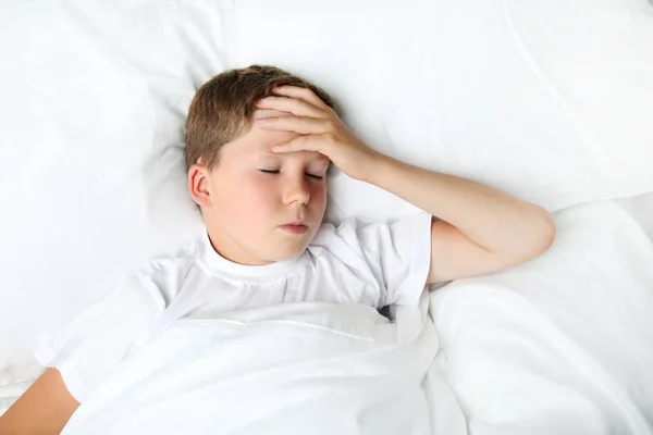 Garçon malade couché dans un lit blanc — Photo