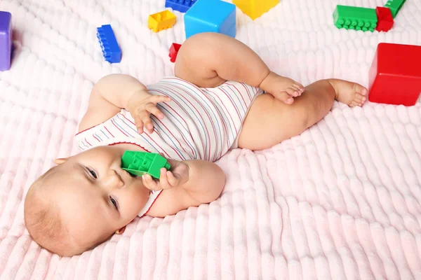 Novorozené miminko s hračkami na růžové lůžko — Stock fotografie