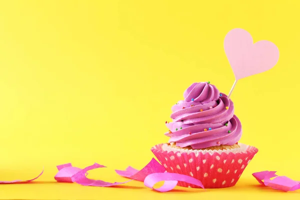 Lekkere cupcake op een gele achtergrond — Stockfoto