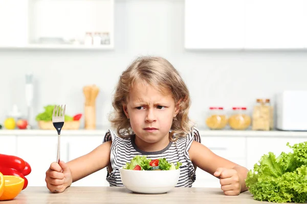 Gadis kecil makan salad di dapur — Stok Foto