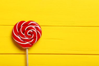 Sarı bir ahşap masa üzerinde tatlı lolipop