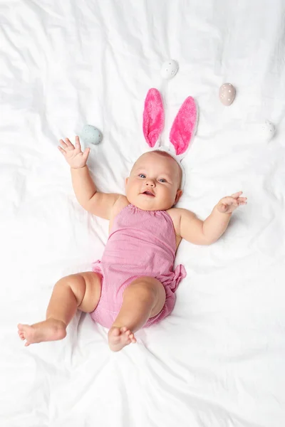Novorozené miminko s králičí uši na bílé posteli — Stock fotografie