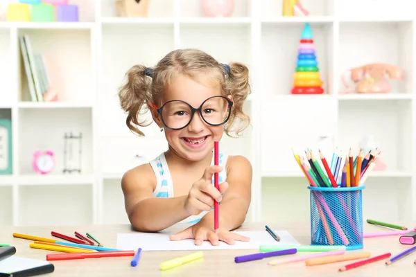 Маленька дівчинка сидить і малює за столом — стокове фото