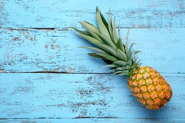 Mavi ahşap masa üzerinde olgunlaşmış ananas — Stok fotoğraf