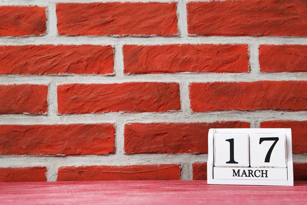 Cube calendar on a brick wall background — Stock Photo, Image