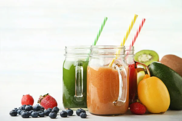 Sweet smoothie in glass jars with fruits — Stock Photo, Image