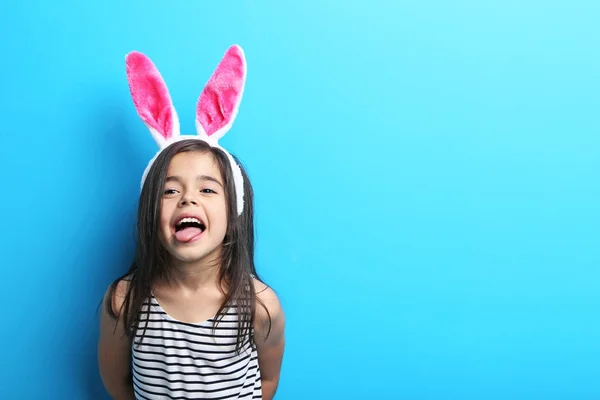 Śliczną dziewczynkę z uszami królika na niebieskim tle — Zdjęcie stockowe