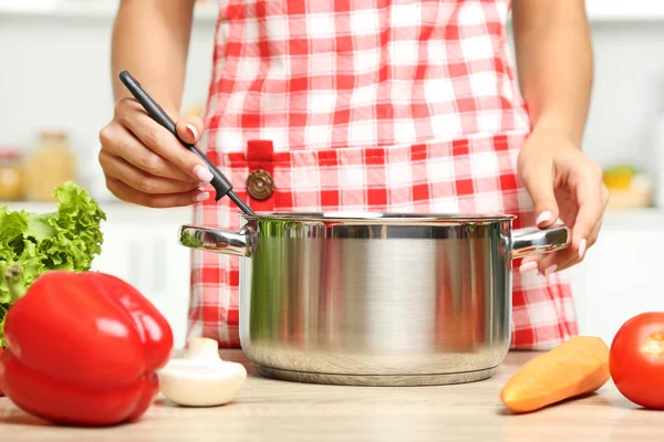 Giovane donna che cucina insalata in cucina — Foto Stock