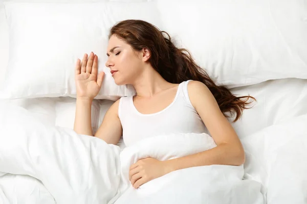 Mujer joven enferma acostada en la cama blanca — Foto de Stock